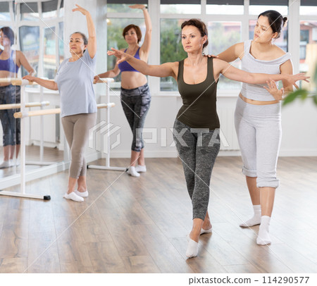 Ballet lesson for amateurs - choreographer teaches women of different ages different ballet steps in studio 114290577
