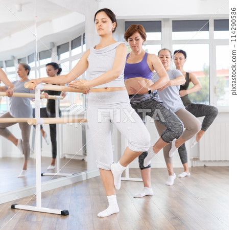 Woman learning passe retire in ballet class for beginners Woman learning passe retire in ballet class for beginners 114290586