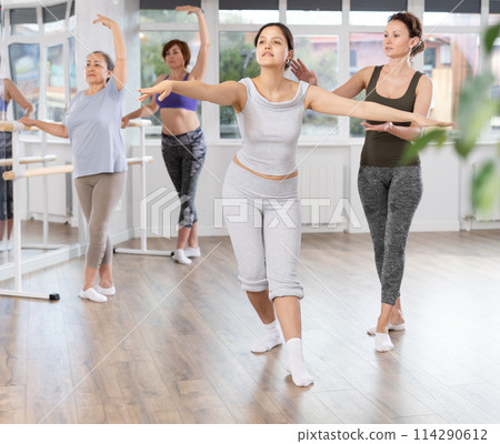 Asian woman learning basics of ballet with female instructor 114290612