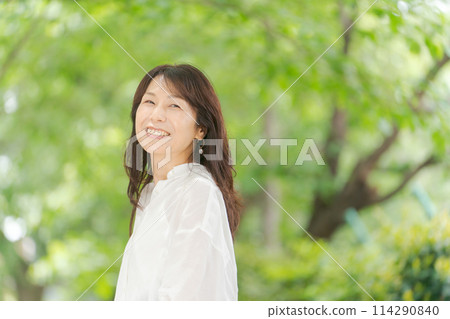 穿著白襯衫的中年婦女在大自然中微笑 114290840