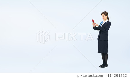 Full-body photo of a woman in the service industry using a smartphone Full-body photo of a woman in the service industry using a smartphone 114291212
