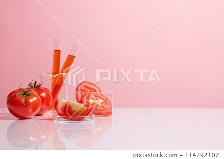 Some fresh tomato pieces and slices contained on glassware placed on the left side of white table over pink background, tomato is a source of several necessary micro nutrients. Copy space, front view Some fresh tomato pieces and slices contained on glassware placed on the left side of white table over pink background, tomato is a source of several necessary micro nutrients. Copy space, front view 114292107