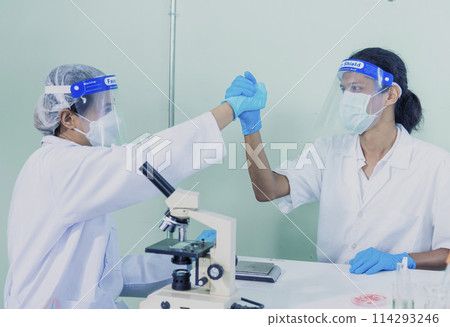Two asian scientist men team high five partner shake hands together. Science Men research chemistry science experiment. Two men biotech coworker success greeting in laboratory. Teamwork successful 114293246