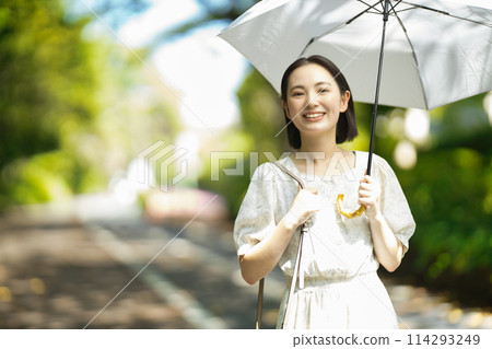 拿著遮陽傘的一個少婦 拿著遮陽傘的一個少婦 114293249