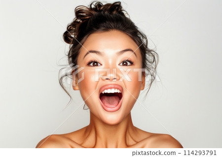 A woman, with her mouth wide open, contorts her face in a comical manner, exuding a whimsical and playful vibe. 114293791