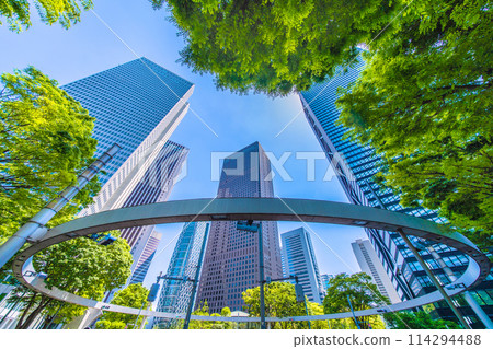 Shinjuku, Tokyo cityscape in Japan. View of Nishi-Shinjuku sign at the intersection behind Shinjuku Police Station and skyscrapers, April 28th 114294488