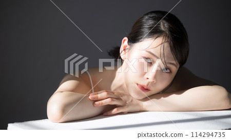 Close-up of a young woman with translucent and lustrous beauty and beauty, with a gray background 114294735
