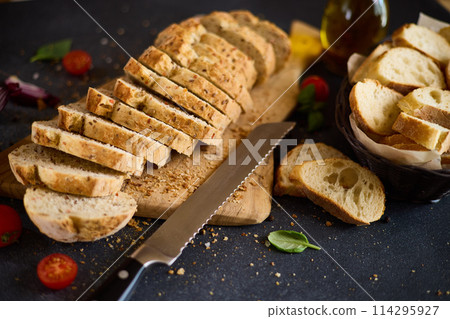 sliced bread on wooden cutting board on dark table sliced bread on wooden cutting board on dark table 114295927