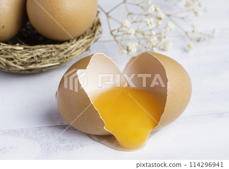 raw broken chicken egg , egg yolk in shell 114296941