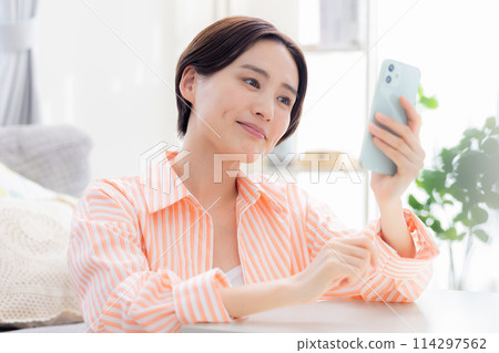 A woman looking at a smartphone 114297562