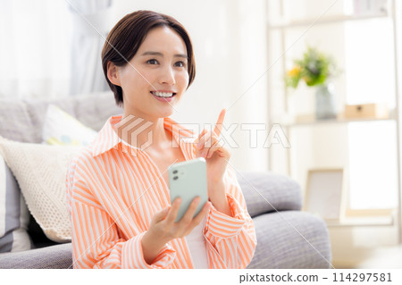 A woman looking at a smartphone 114297581