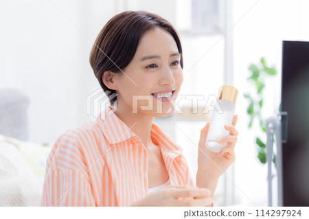 Beauty image: A woman doing skin care while looking in the mirror 114297924