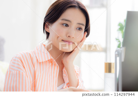 Beauty image: A woman doing skin care while looking in the mirror Beauty image: A woman doing skin care while looking in the mirror 114297944