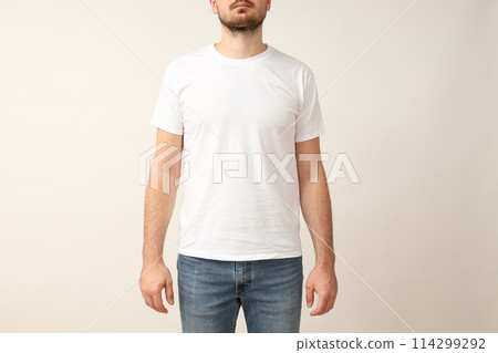 A young guy in a white T-shirt on a light background A young guy in a white T-shirt on a light background 114299292