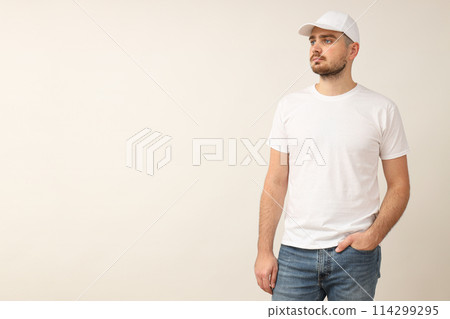 A young guy in a white T-shirt on a light background 114299295