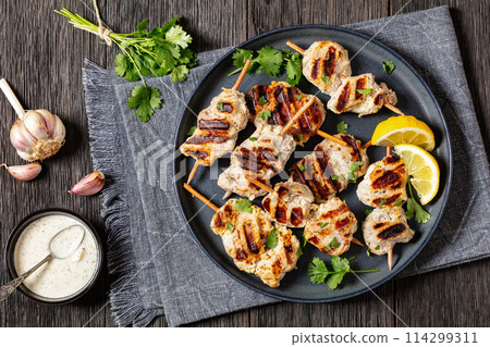 grilled mini pork skewers on a plate, top view grilled mini pork skewers on a plate, top view 114299311