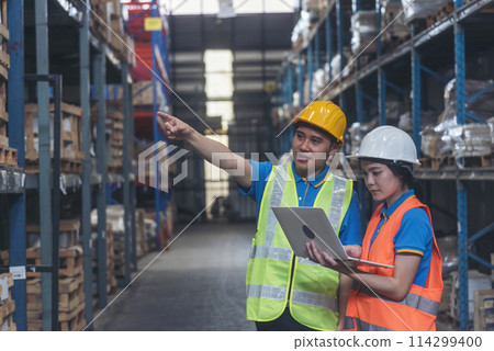 Warehouse management team using computer laptop check stock inventory. Asian men women worker use software computer type keyboard goods shelf. Teamwork logistics staff counting stock store inventory 114299400