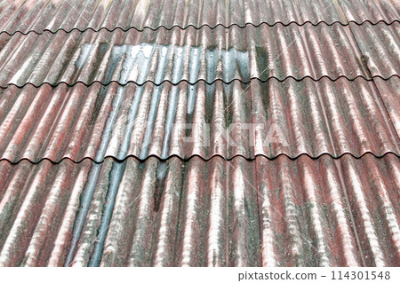 Old rusty corrugated iron roofing with rain drops.  Roofing background 114301548