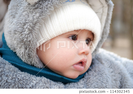 Happy little baby boy making outdoors in winter. Cute toddler in winter cloth. Child having fun on cold day. Winter walk outdoors 114302345