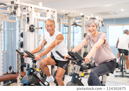 Senior couple exercising at a fitness gym Senior couple exercising at a fitness gym 114302675