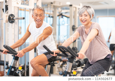 Senior couple doing aerobic exercise at the gym Senior couple doing aerobic exercise at the gym 114302677