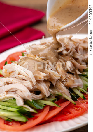 Pouring sauce on bang bang chicken Pouring sauce on bang bang chicken 114303542