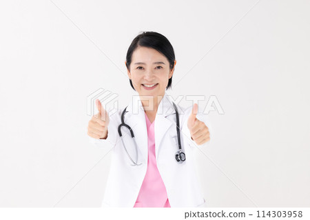 Middle-aged woman in white coat thumbs up 114303958