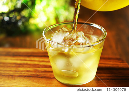 Cold green tea poured into a glass 114304076