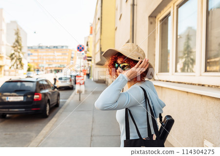 portrait young woman against backdrop of city life 114304275