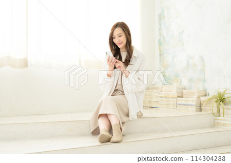 A woman looking at her smartphone indoors A woman looking at her smartphone indoors 114304288