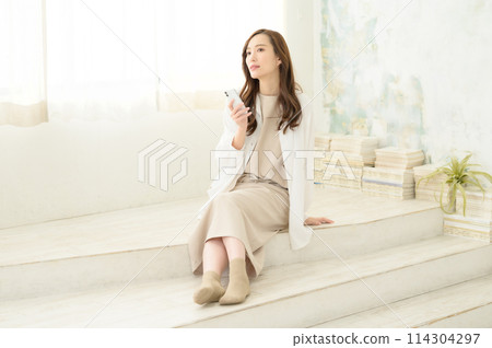 在室內看智慧型手機的女人 在室內看智慧型手機的女人 114304297