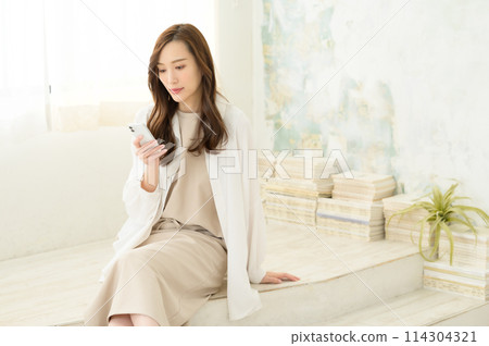 在室內看智慧型手機的女人 在室內看智慧型手機的女人 114304321