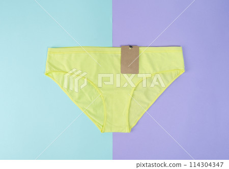women yellow panties with label. Top view advertising and shopping concept. Flat lay, copy space, mock up. 114304347