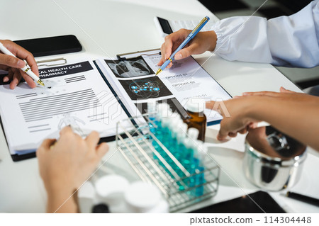 Doctor team, analysis the blood test examination results and medication usage of the patient on the chart, medical check-up concept. 114304448
