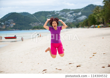 Happy middle aged tourist jumping at chaweng beach in koh samui ,Thailand. 114304532