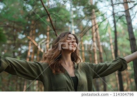 Beautiful girl in fairy pine forest. Relaxed woman wearing green dress breathing fresh air standing alone in a green wood. Sunny summer day, wild nature, mood vacation, relax. Be free, love forest Beautiful girl in fairy pine forest. Relaxed woman wearing green dress breathing fresh air standing alone in a green wood. Sunny summer day, wild nature, mood vacation, relax. Be free, love forest 114304796