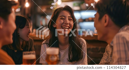 Group of young Asian friends having fun, laughing and enjoying drinking beer together in urban bar or cafe at night, sharing moments of joy friendship. They feeling happy relax having party. 114304827