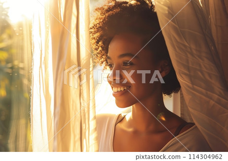 Young african american woman unveil curtain and looking out of window in the morning. Beautiful girl after waking up fully rested and open curtains. Start the new day with happiness. Relax, resting 114304962