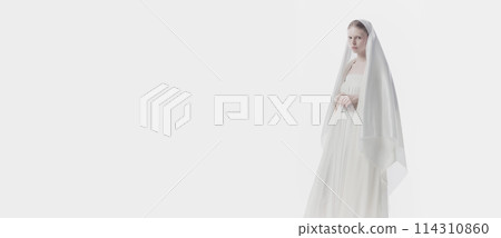 Banner. Young woman shrouded in gossamer white veil, creating ghostly yet angelic appearance. against white studio background. Copy pace. Banner. Young woman shrouded in gossamer white veil, creating ghostly yet angelic appearance. against white studio background. Copy pace. 114310860