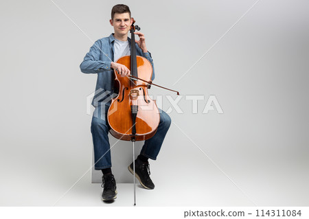 Attractive man musician playing cello on concert 114311084