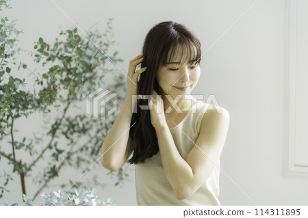 Young woman combing her hair Young woman combing her hair 114311895