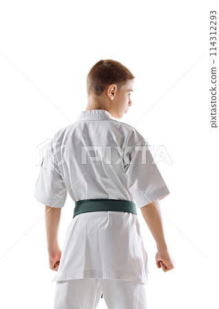 Back view image of teen boy, karate athlete posing in white kimono with green belt isolated on white studio background Back view image of teen boy, karate athlete posing in white kimono with green belt isolated on white studio background 114312293