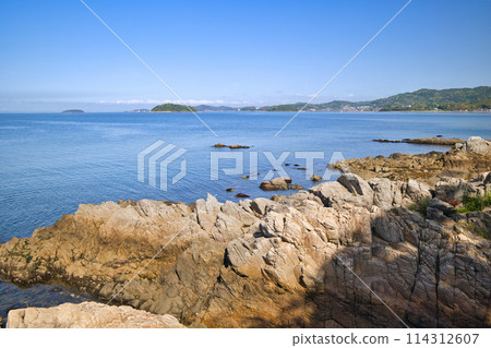 Crystal clear blue waters in a tide pool amongst rugged rocks 114312607