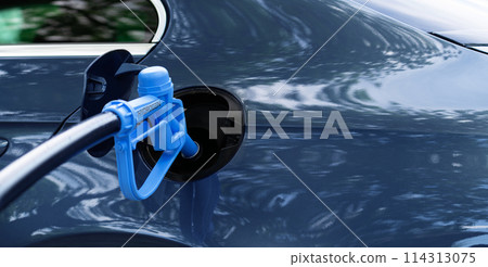 Close up of fuel cell car with connected hydrogen fueling nozzle. 114313075