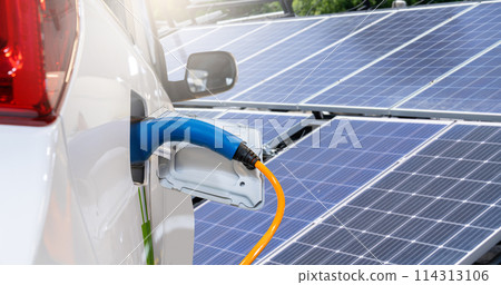 Close up of electric car with a connected charging cable on the background of solar panels.. 114313106