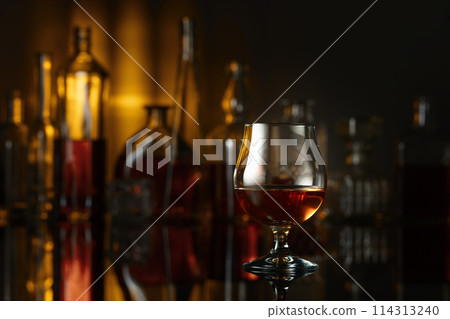 Snifter of brandy on a black table in bar. 114313240