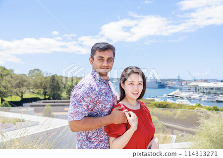 Indian boyfriend and Japanese girlfriend hugging from behind 114313271