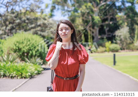 A young Japanese woman walking in a park in Sydney 114313315