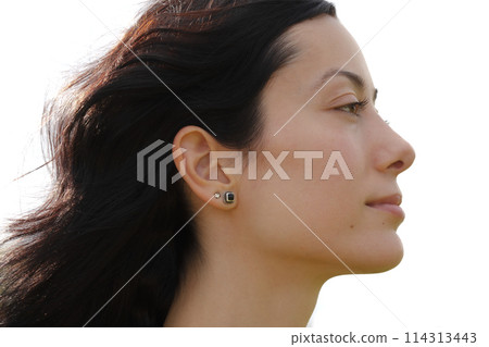 A profile portrait of a woman with hair blowing in the wind 114313443