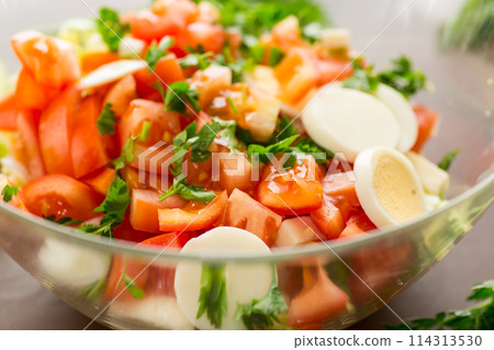fresh vegetable salad, cabbage, tomatoes in a bowl on a wooden table 114313530